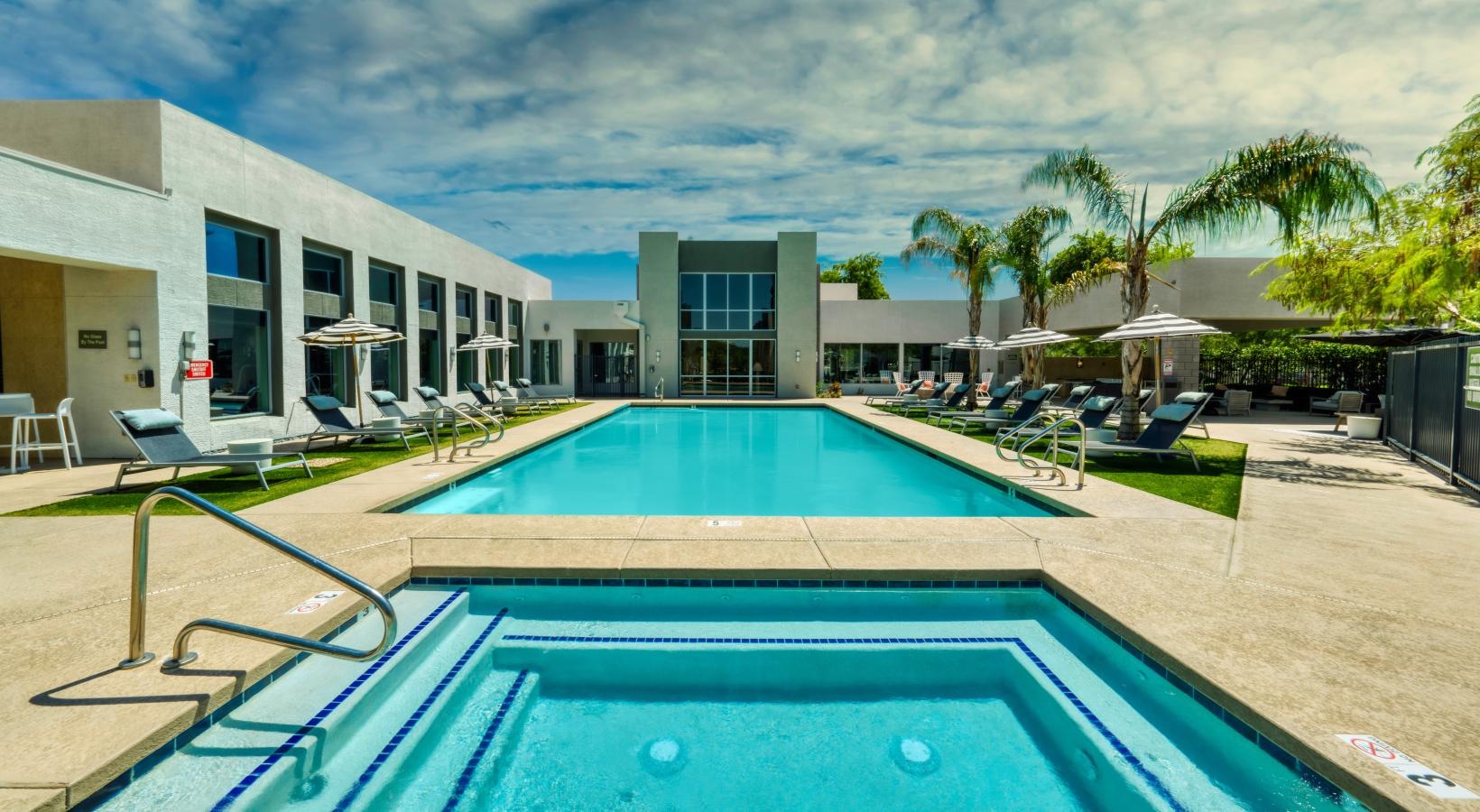 Relax and unwind poolside a swimming pool in front of a building