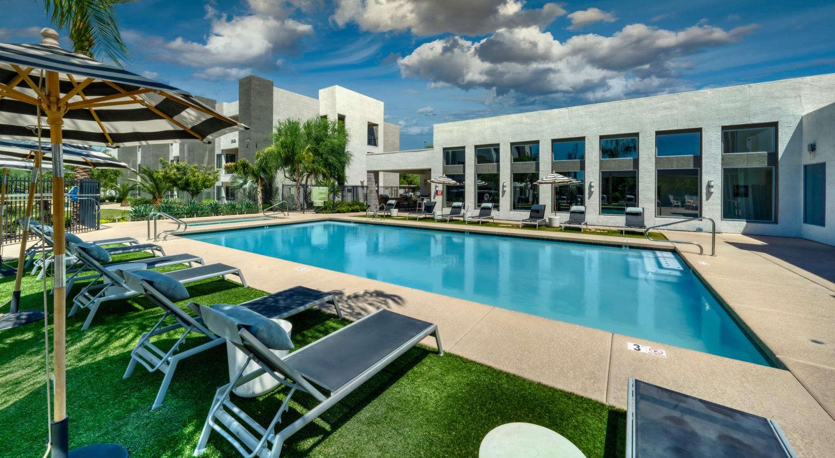 Resort-style swimming pool a swimming pool with chairs around it
